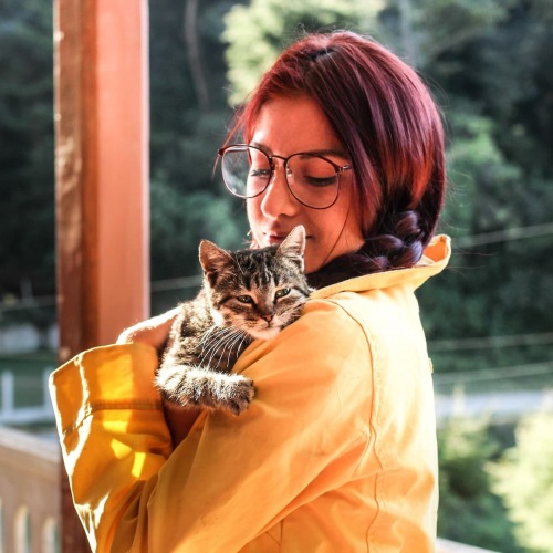 lifestyle image of a woman holding a cat outdoors